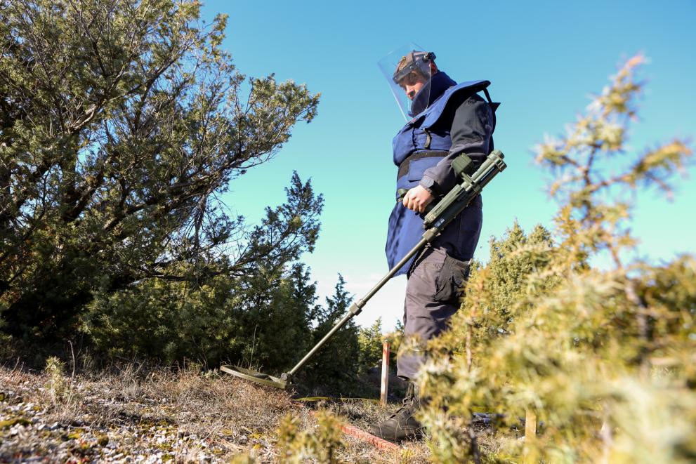 Image of a man using a mine detector